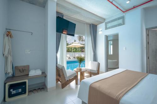 um quarto de hotel com uma cama e uma piscina em The Up Hotel Phu Quoc Island - The Poolside Escape em Duong Dong