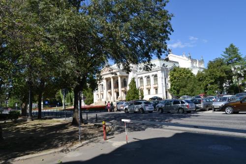 a large white building with cars parked in a parking lot at Casa de Oaspeți Sfântul Nicolae in Iaşi