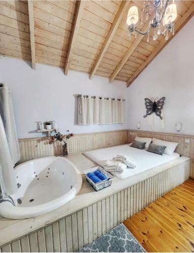 a large room with a bath tub and a butterfly on the ceiling at צימר חן בחד נס in Had Nes