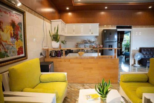 un soggiorno con mobili gialli e una cucina di Villa mini 3 phòng ngủ Đà Lạt a Xuan An