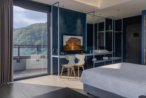 a bedroom with a bed and a bathroom with a tub at OA HOTEL Wushih Marina in Toucheng