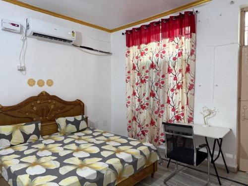 a bedroom with a bed and a desk and a curtain at Pilgrim Abode Teerth Yatriyon ka Thikana in Jāmb