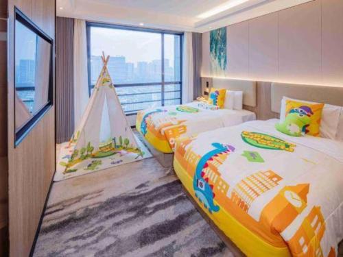 a bedroom with two beds and a play tent at Jiaxing Fortune Holiday Hotel in Jiaxing