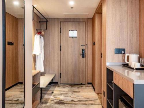 a small bathroom with a door and a sink at Jiaxing Fortune Holiday Hotel in Jiaxing