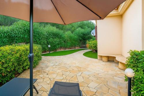 a patio with a table and an umbrella at Villino Tiriddò Porto San Paolo in Porto San Paolo