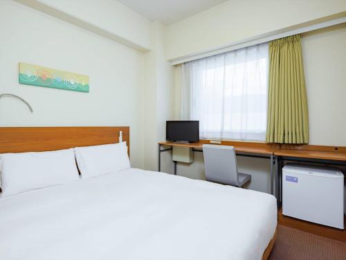 a hotel room with a bed and a desk at Comfort Inn Suwa Inter in Suwa