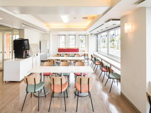 a classroom with tables and chairs and a tv at Comfort Inn Hitachinaka in Hitachinaka