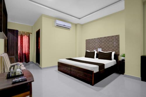 um quarto com uma cama e uma escrivaninha em - Hotel O Machilipatnam Railway Station Formerly Hasini Celebrations em Machilīpatnam
