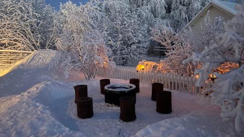 a yard covered in snow with a fence at Luxury City Cottage in Rovaniemi