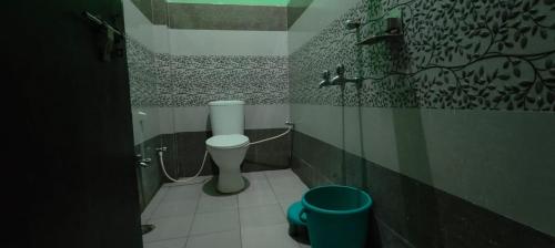 Un baño con un inodoro y un cubo dentro. en Royal Kashi Lodge, en Prayagraj