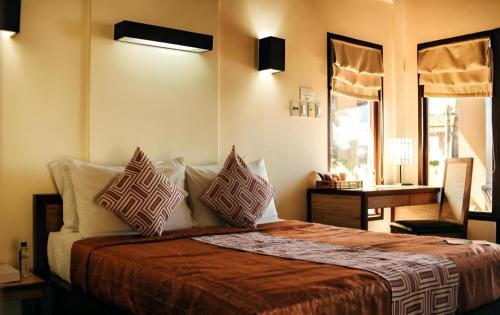 Dalumpinas OesteKahuna Beach Resort and Spa的一间卧室，配有一张床、枕头和一张桌子