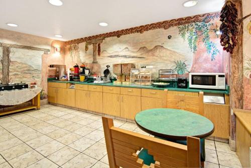 a large kitchen with a table and a large mural at Microtel Inn & Suites by Wyndham Albuquerque West in Albuquerque