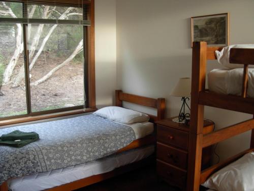 En eller flere senge i et værelse på Honeymyrtle Cottage