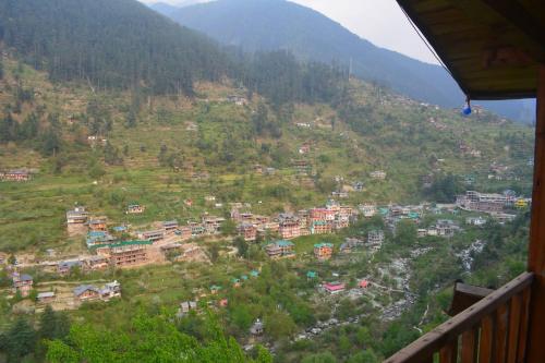 uma vista para uma aldeia numa montanha em Skytouch mud-house cottage em Jibhi