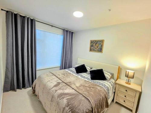 a bedroom with a bed and a large window at 2 bedroom heart of Central Surrey in Surrey
