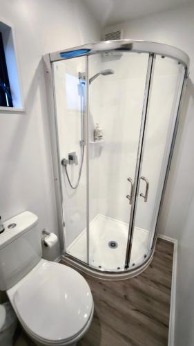 a bathroom with a shower and a toilet at Kawatiri Palms in Westport