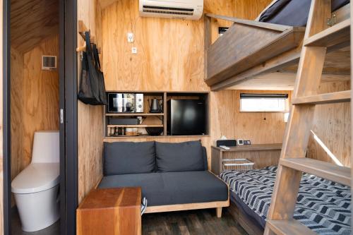 a tiny house with a bunk bed and a couch at HOTEL BOTH in Shari