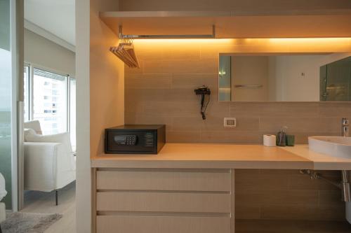 a bathroom with a counter with a microwave and a sink at KingBed Beachfront-Pool Condo & Kitchen,Playground,TV,Wifi in Jomtien Beach