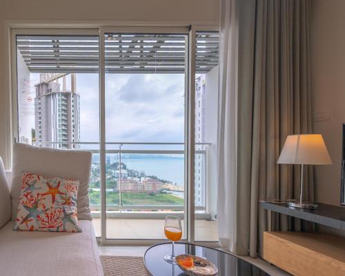 a living room with a large window with a view at KingBed Beachfront-Pool Condo & Kitchen,Playground,TV,Wifi in Jomtien Beach