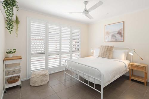 a white bedroom with a bed and a window at Golden Beach Bungalow - 500m to the beach in Golden Beach