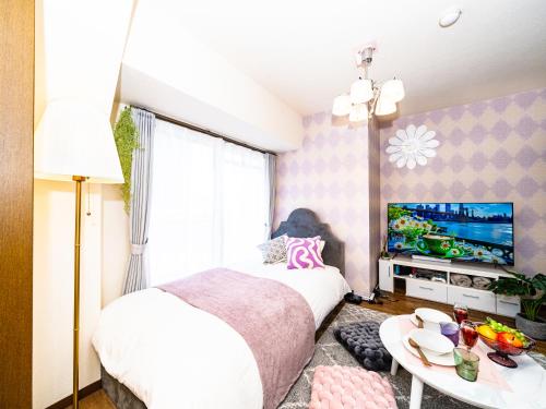 a bedroom with a bed and a tv and a table at MY STORY Cute 605ｰ瓦町駅徒歩6分 in Takamatsu
