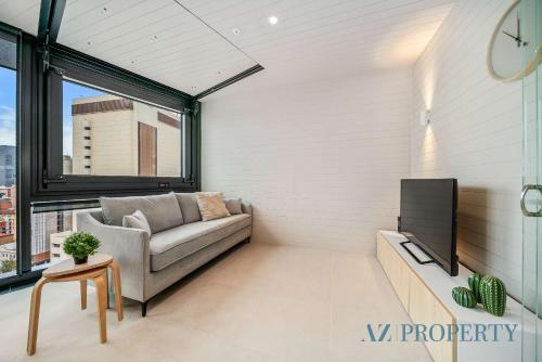 a living room with a couch and a tv at Metro Nest Light-Filled 1BR in CBD in Perth