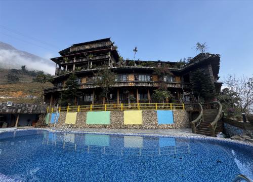 a large building with a swimming pool in front of it at Muong Hoa River View Hotel in Sa Pa