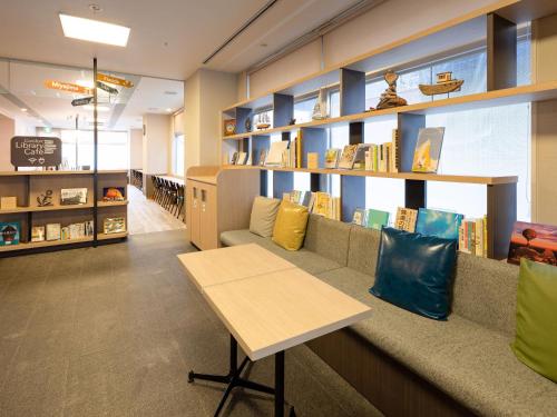 a library with a couch and shelves of books at Comfort Hotel Kure in Kure