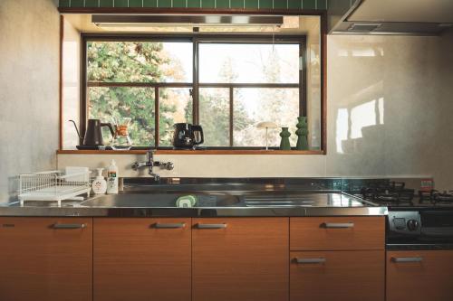 a kitchen with a sink and a window at Karabiner House Myoko in Myoko