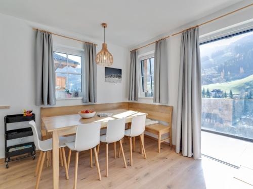 a dining room with a wooden table and white chairs at Modern Chalet in Mühlbach am Hochkönig near Ski Area in Mühlbach am Hochkönig