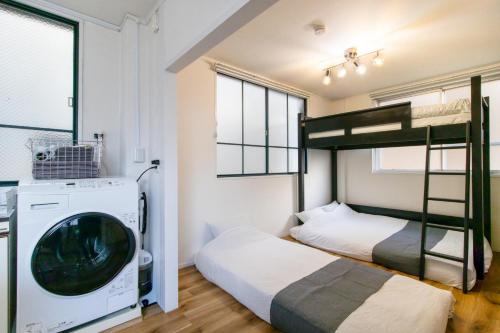 a bedroom with two bunk beds and a washing machine at epilogue hotel 302 in Fukuoka