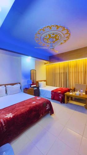 a hotel room with two beds and a blue ceiling at Hotel Blue Sky Mirpur in Dhaka