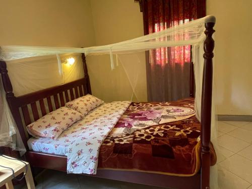 ein Schlafzimmer mit einem Himmelbett in der Unterkunft Entebbe gardens holiday home in Entebbe