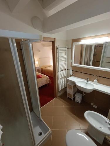 a bathroom with a sink and a toilet and a mirror at Villa Marini Trevisan in Aviano