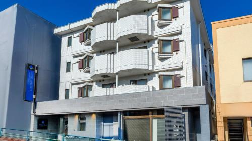 a tall white building with balconies on it at HOTEL MYSTAYS Higashi Jujo in Tokyo