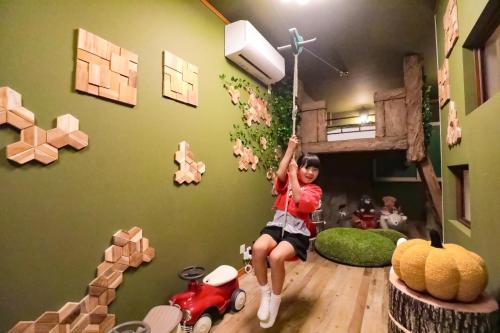 a young girl hanging from a tree house in a room at Fantasy Lodge in Tokyo