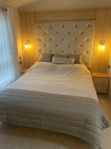 a bedroom with a large bed with a large headboard at Rockley Park, Poole, Stunning Sea View, Close to Beach in Poole
