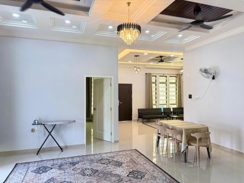 a living room with a table and a couch at CHAM Homestay PCB in Kota Bharu