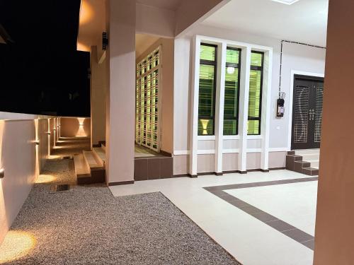 a hallway of a home with glass doors and stairs at CHAM Homestay PCB in Kota Bharu