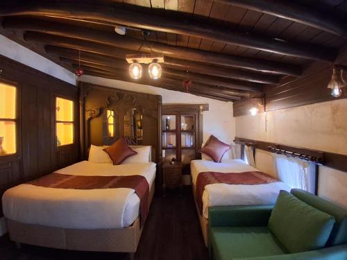 a hotel room with two beds and a chair at Yılmazhan Konağı Butik Otel in Gaziantep