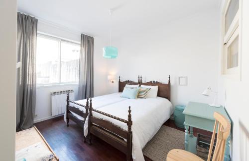 Un dormitorio con una cama y un escritorio y una ventana. en LovelyStay - Porto Beach Apartment, en Oporto