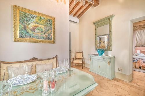 a dining room with a glass table and a painting on the wall at Villa MonteLandi in Montalcino