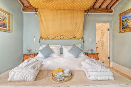 a bedroom with a large white bed with two chairs at Villa MonteLandi in Montalcino