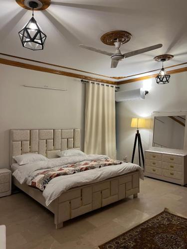 a bedroom with a bed and a ceiling fan at SereneNest in Islamabad