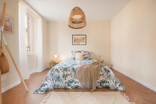 Un dormitorio con una cama y una alfombra en el suelo. en Elégant Appartement Lumineux Proche Cathédrale l Clim, en Albi