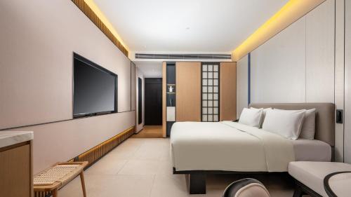 a hotel room with a bed and a flat screen tv at Holiday Inn Express Guangzhou Baiyun Airport T2 by IHG in Huadu