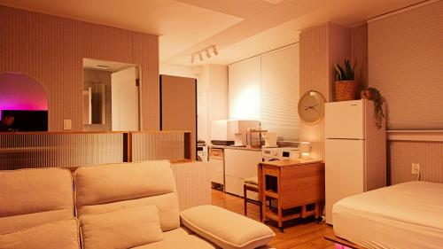 a living room with a couch and a refrigerator at Ansan Minimal Studio in Ansan