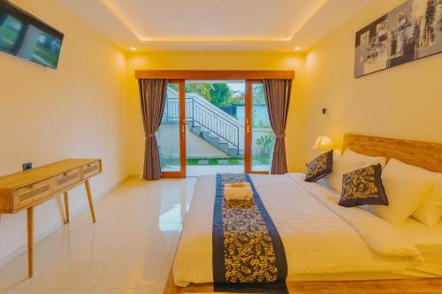 a bedroom with a bed with a desk and a window at Griya Mandara Ubud Villa in Ubud