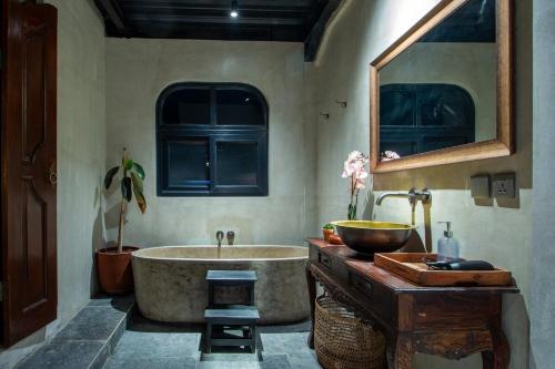 a bathroom with a large tub and a sink at Warehouse Loft - Chic industrial aesthetic loft in Dalung