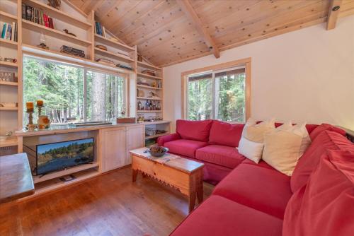 Una sala de estar con un sofá rojo y un televisor. en Tahoe Pines Beach Retreat home, en Tahoe Pines